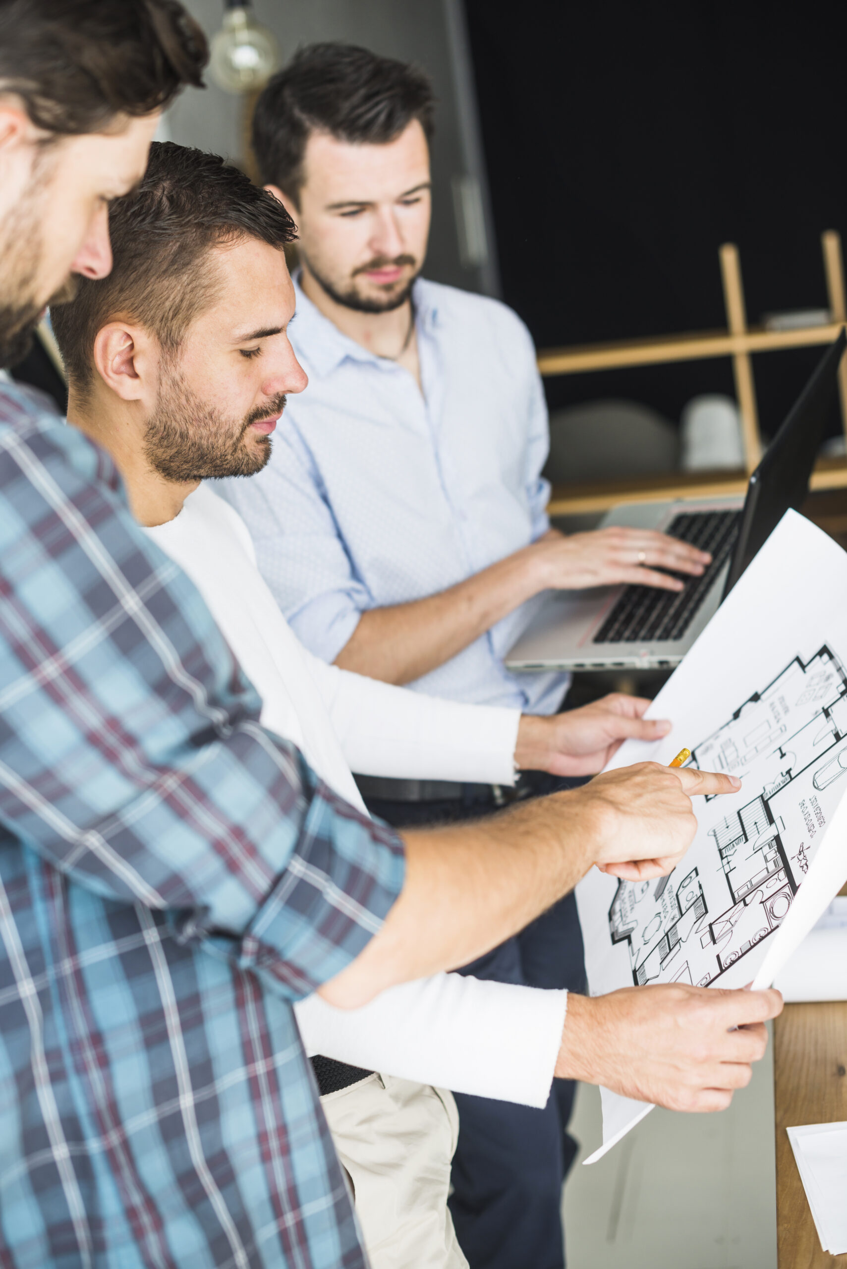 group-male-architect-having-discussion-blueprint